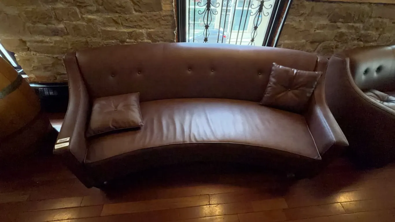 Curved Brown Faux Leather Sofa with Pillows