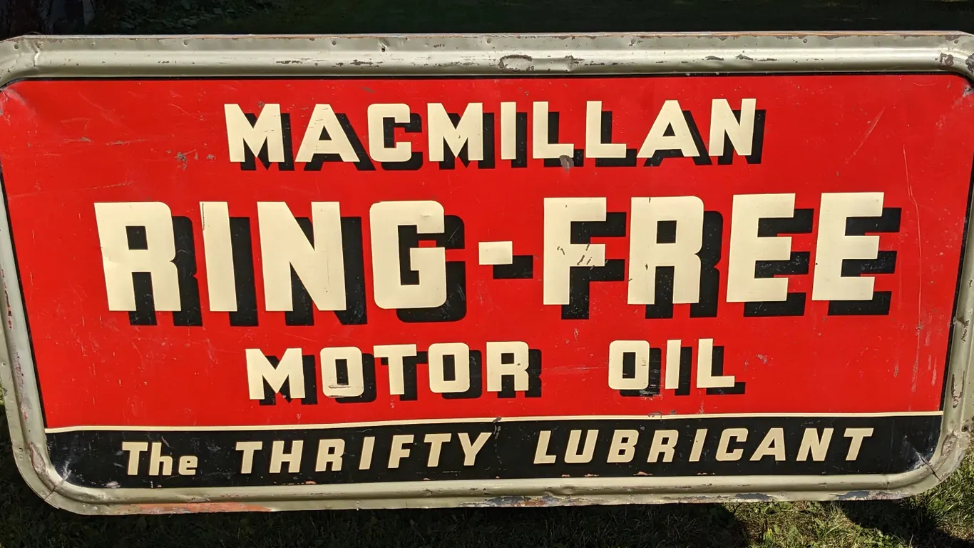 EMBOSSED TIN SIGN MACMILLAN RING-FREE MOTOR OIL THE THRIFTY LUBRICANT