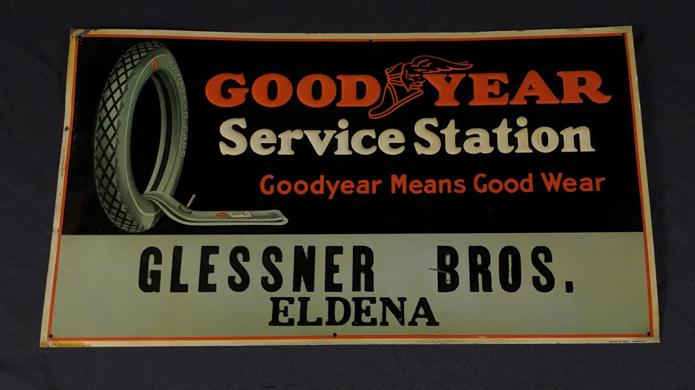 NOS EMBOSSED TIN SIGN GOOD YEAR SERVICE STATION GLESSNER BROS ELDENA