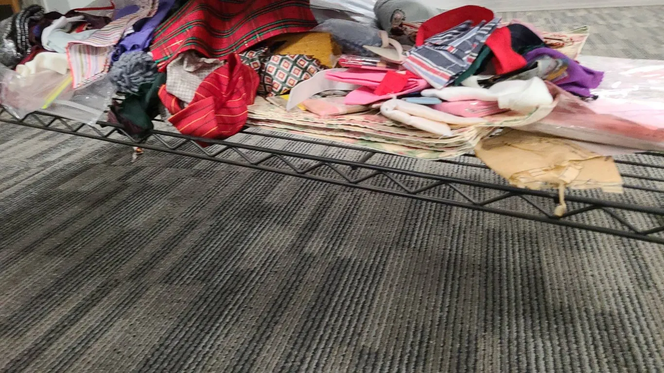 Bottom Shelf of the 3rd Cart with Assorted Fabric Remnants, Pattern Pieces, and Sewing Notions Colle