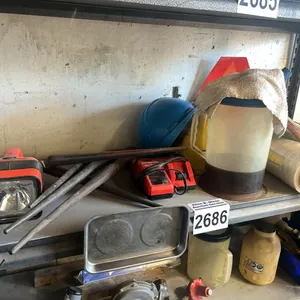 SHELF OF MILWAUKEE M12 & M18 BATTERY CHARGER, 2 -18V MAKITA BATTERIES, MAKITA CHARGER, MAGNETIC PAN, HAMMER WRENCHES, HARD HATS, ROLL OF SHRINK WRAP &