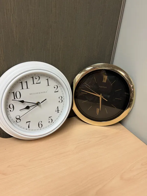 Two Quartz Wall Clocks Including Muller & Noble White Round Clock and Ingraham Black & Gold Clock