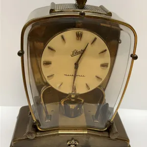 Schatz Electonic Brass Mantel Clock With Fleur-De-Lis Embellishment and Curved Glass Case