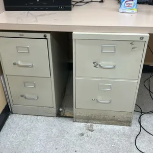 2-drawer metal filing cabinets. Features beige finish, integrated label holders, and metal pull handles. Desk and surrounding contents not included.