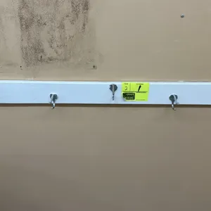 Wooden coat hanging racks. Features white painted wood construction with (5) dual-prong metal coat hooks per rack. 5'L each. Wall-mounted design. Hang