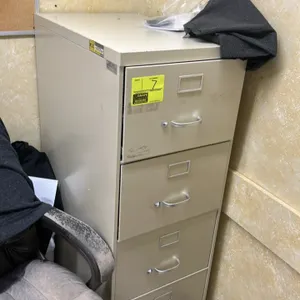 Metal 4-drawer vertical filing cabinet. Features four pull-out drawers with bow handles and integrated label holders. Putty/beige finish. Contents not
