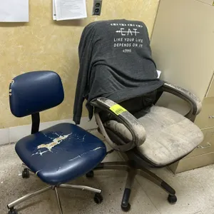 Rolling office chairs. Includes (1) blue vinyl task chair and (1) upholstered executive chair. Each mounted on a 5-star rolling caster base. Note: Uph