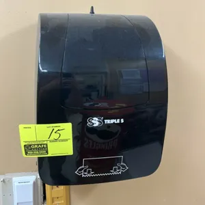 Triple S paper towel dispenser. Features black plastic housing and manual bottom feed design. Wall-mounted.