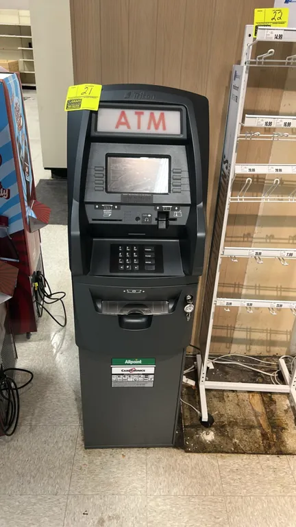 Triton Traverse retail ATM machine. Features illuminated ATM topper, color display screen, numeric PIN pad, card reader, receipt printer, and cash dis