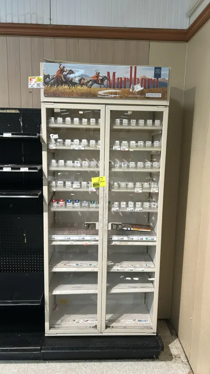 Metal 2-door locking multi-tier tobacco merchandiser. Features Marlboro graphic header panel, double glass doors with locking handles, and multi-tier