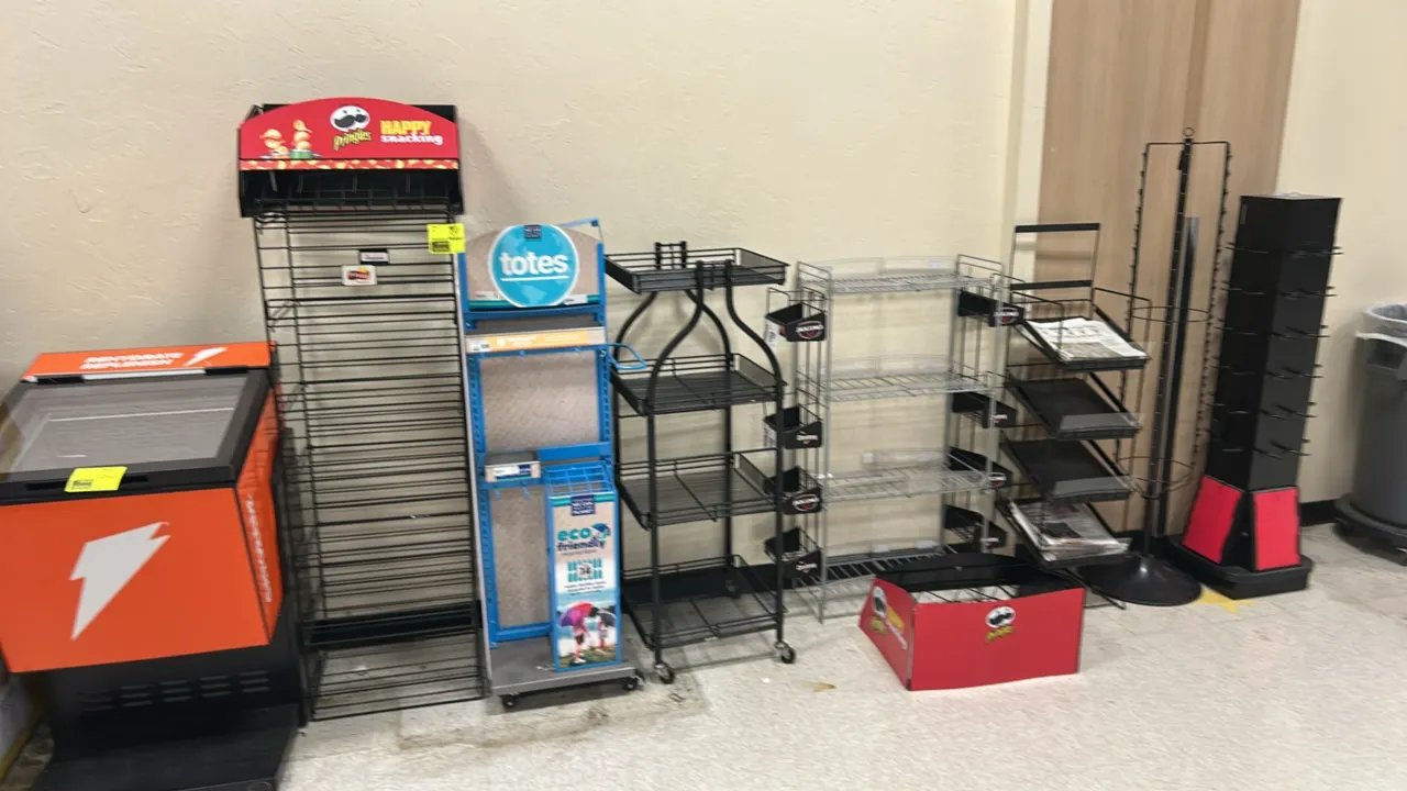 Assorted metal multi-tier retail merchandiser display racks. Includes various floor-standing and spinning display fixtures such as rolling wire displa