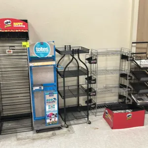 Assorted metal multi-tier retail merchandiser display racks. Includes various floor-standing and spinning display fixtures such as rolling wire displa