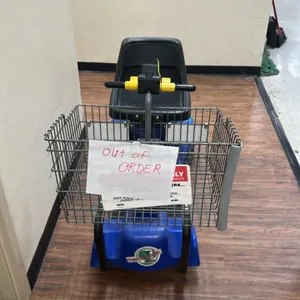 Mart Cart motorized shopping cart. Features front wire shopping basket, dual throttle controls, and molded seat. Note: Unit is marked as out of order.