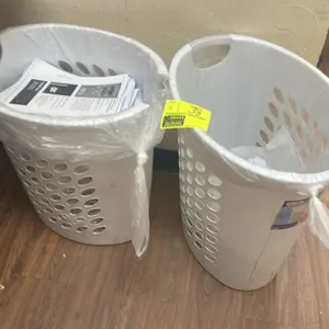 Plastic laundry hampers. Features white poly construction, perforated ventilation holes, and integrated carry handles. Contents not included.