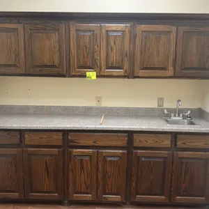 8' laminate countertop with upper and lower cabinets and stainless steel sink. Features woodgrain finish cabinetry, single-basin stainless steel drop-