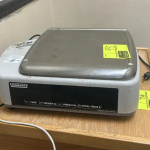 Hobart Quantum digital deli scale and printer. Features stainless steel weighing platter, integrated operator keypad with display, and customer displa