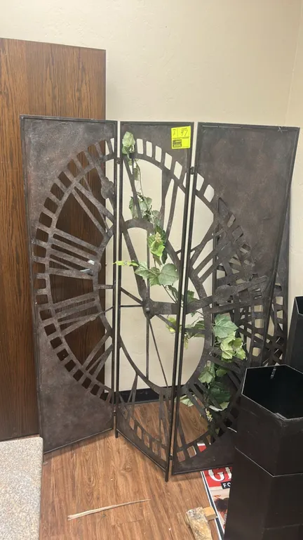 Metal 3-panel folding room dividers. Features cut-out Roman numeral clock face design, rustic bronze-tone finish, and hinged panel construction. Decor