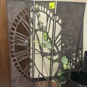 Metal 3-panel folding room dividers. Features cut-out Roman numeral clock face design, rustic bronze-tone finish, and hinged panel construction. Decor