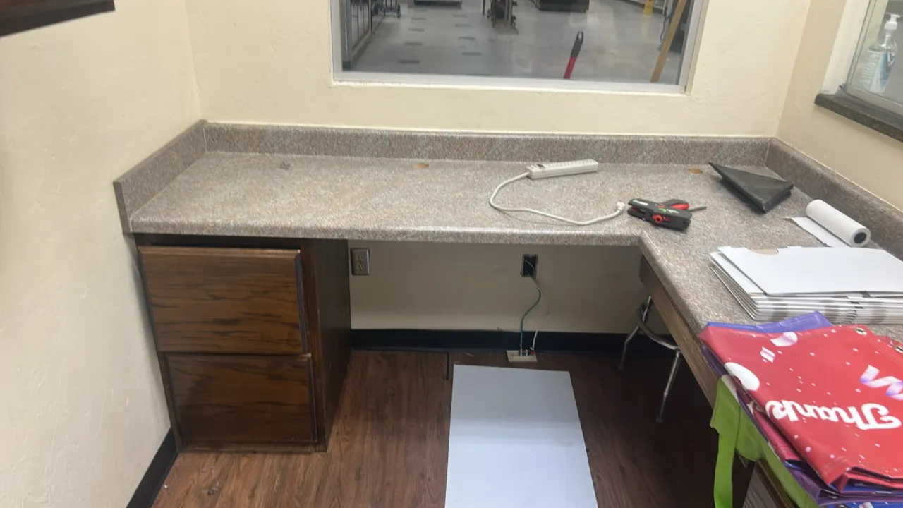 L-shaped laminate countertop with base and wall cabinets. Features speckled faux-stone laminate countertop with integrated backsplash, woodgrain finis
