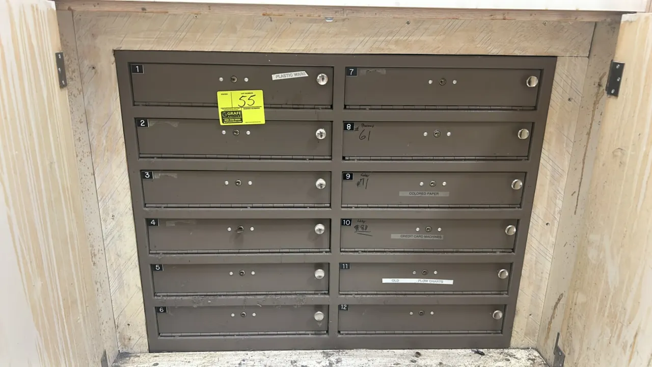 Horizontal commercial mailbox unit. Features 12 compartments arranged in two columns of six with numbered doors (1-12), individual key locks, and bron