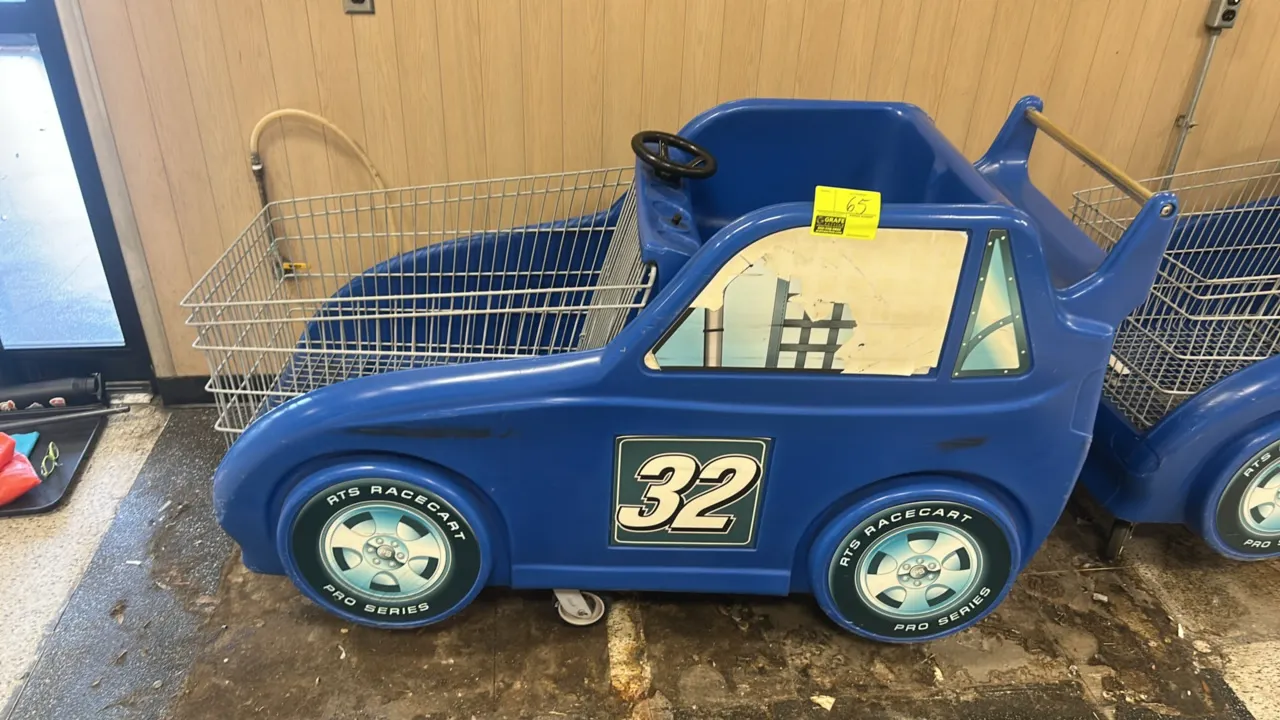 RTS Racecart Pro Series children's race car shopping cart. Features molded blue plastic race car body with #32 graphics, single child seating compartm