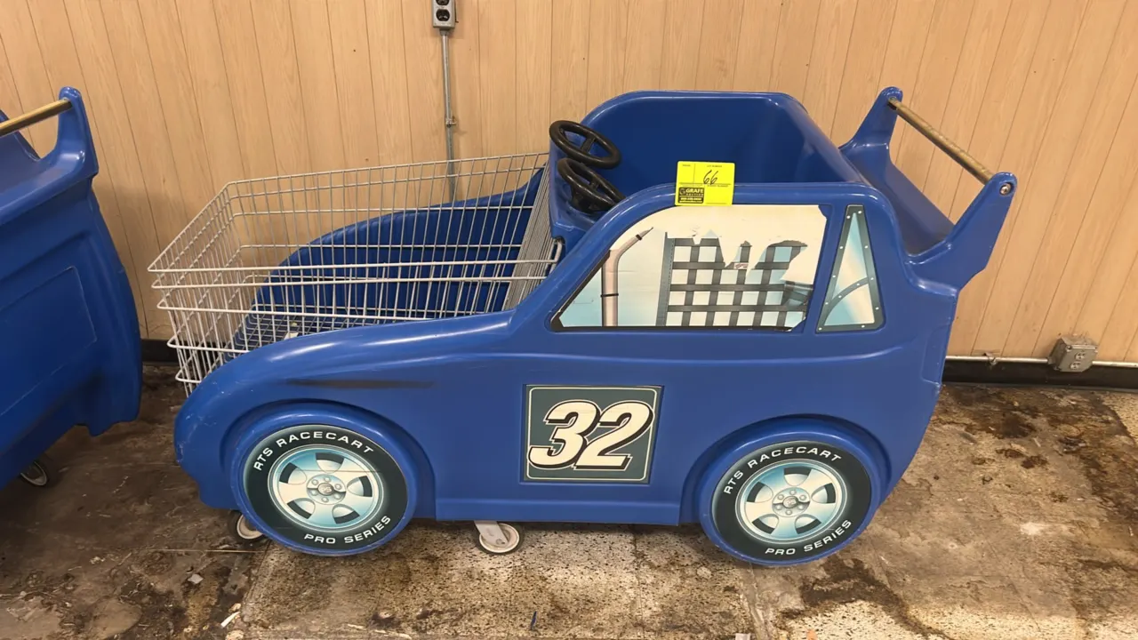 RTS Racecart Pro Series child race car shopping cart. Features blue molded plastic car body with #32 decals, dual child seating with dual steering whe