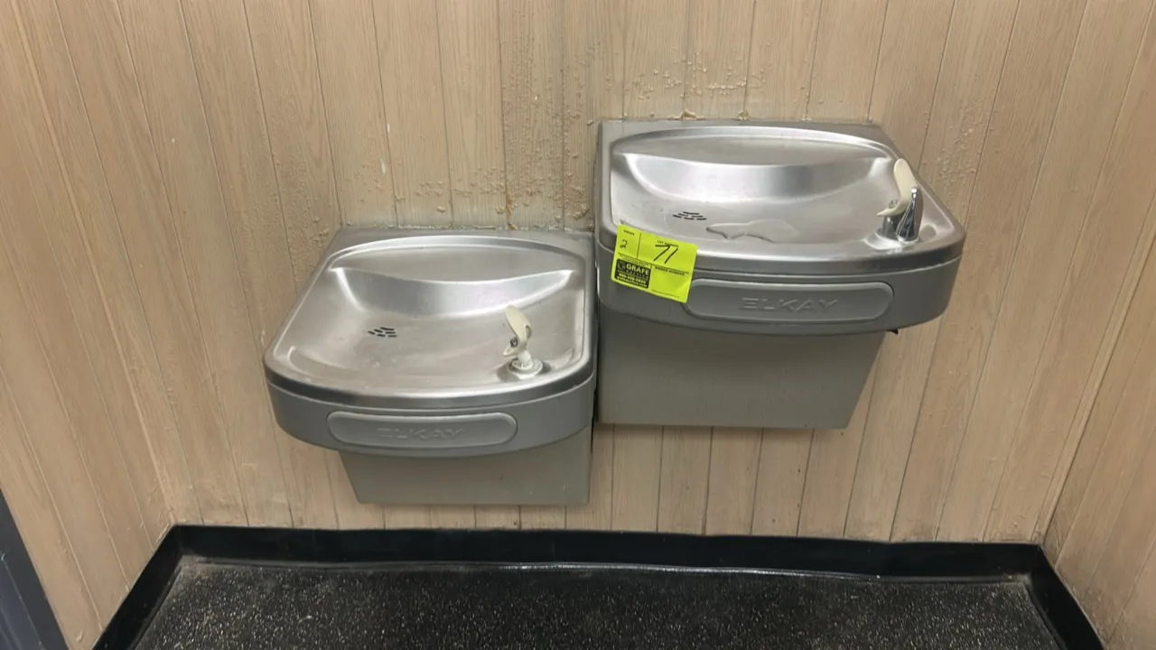 Elkay drinking fountains. Features stainless steel basins with front push-bar activation. Wall-mounted design.
