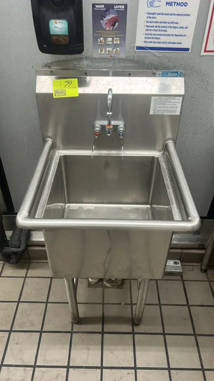 Advance Tabco 23" stainless steel hand sink. Features a single-compartment basin, integrated high backsplash, splash-mount gooseneck faucet with wrist