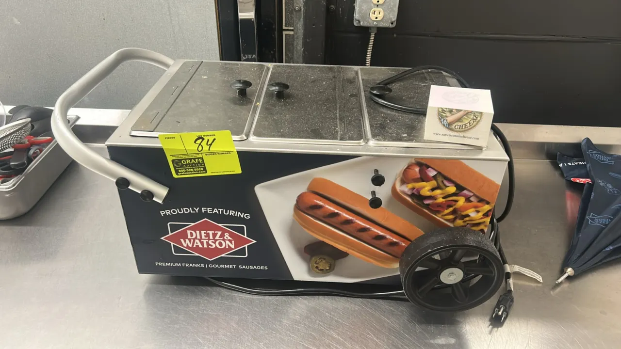 Tabletop hot dog mini cart steamer. Features stainless steel food well compartments with hinged lids, Dietz & Watson graphic wrap, side wheels, push h