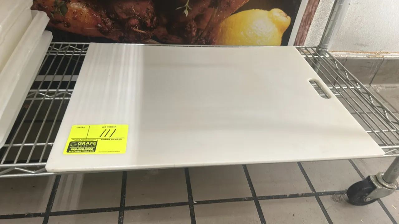 Poly cutting board. Features white polyethylene construction with an integrated cutout handle. Dimensions: 24" x 18". Wire shelf cart not included.