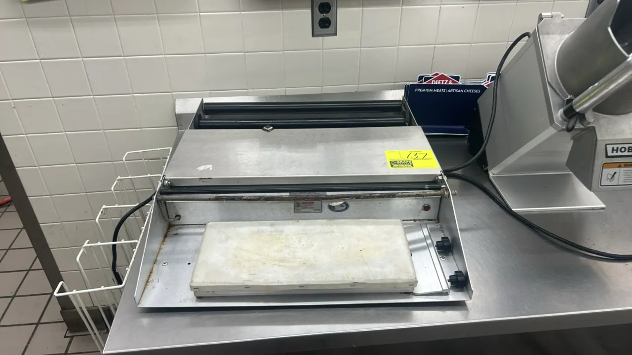 Heat Seal 600A 2-roll stainless steel tabletop film wrapper. Features 2-roll film dispensing capacity, heated cut-off rod, and heated sealing plate.