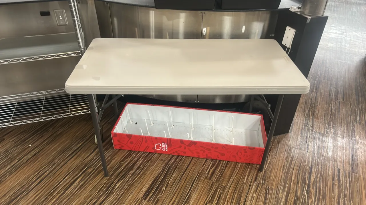 Lifetime folding table. Features a molded polyethylene top with folding metal legs. 4'L. Display box underneath and background items not included.
