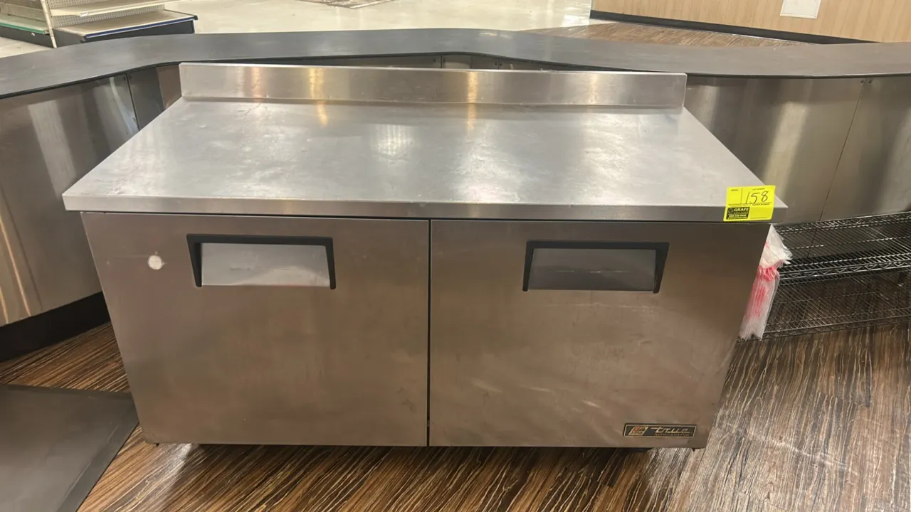 True TWT-60 2-door stainless steel worktop refrigerator. Features integrated backsplash, adjustable wire shelving, and self-contained refrigeration. 6