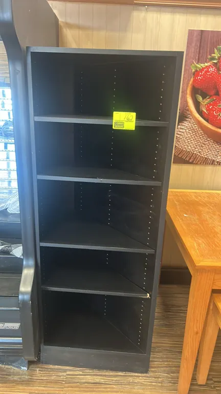 Laminate multi-tier corner shelving unit. Features black laminate construction, angled shelves, and adjustable shelf height positions.