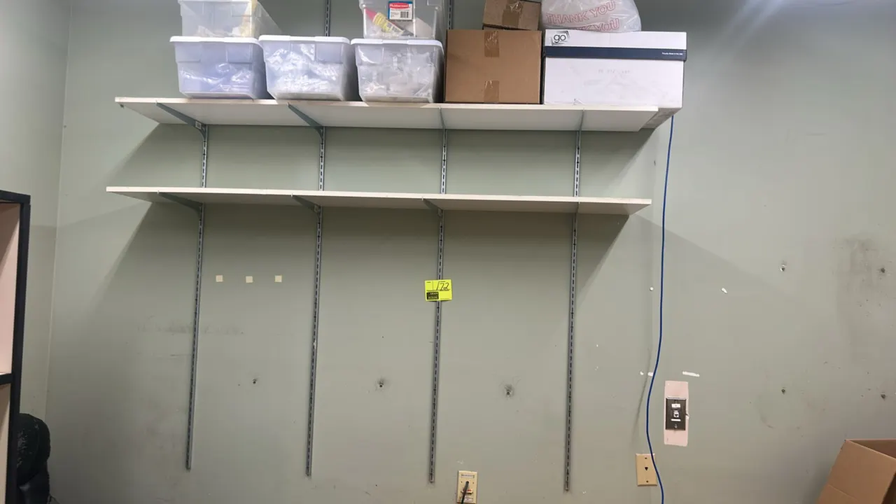 6'L of laminate wall-mounted shelving. Features (2) tiers of white laminate shelves with wall standards and shelf support brackets. Contents not inclu