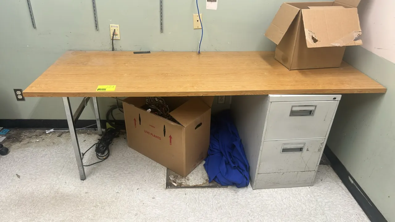 Laminate office desk. Features woodgrain laminate top, right-side 2-drawer metal file pedestal base, and chrome metal support legs. Dimensions: 84" x