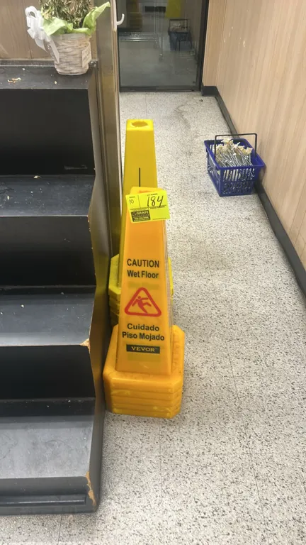 Yellow poly wet floor safety cones. Features stackable design with top openings, multi-sided Caution Wet Floor graphics, and bilingual text.