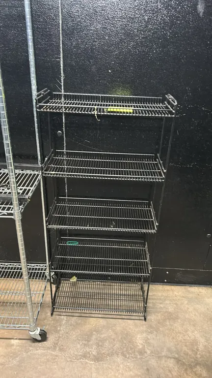 Metal 5-tier wire display rack. Features black coated wire construction with 5 shelves. Dimensions: 22" x 11".