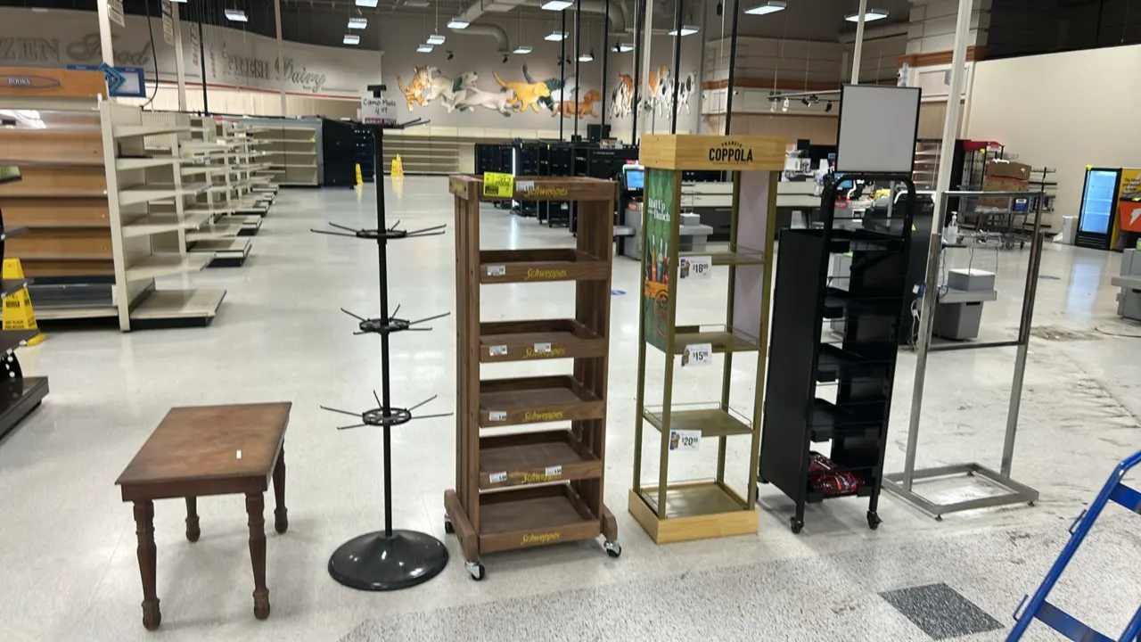 Assorted retail merchandisers, sign stand, and display table. Includes (4) assorted metal and wooden display racks, (1) 24" metal sign stand, and (1)