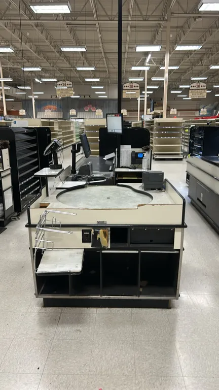 Killion single-belt laminate checkout lanes. Features motorized conveyor belt, rotating bagging carousel station, lower storage compartments, and prot
