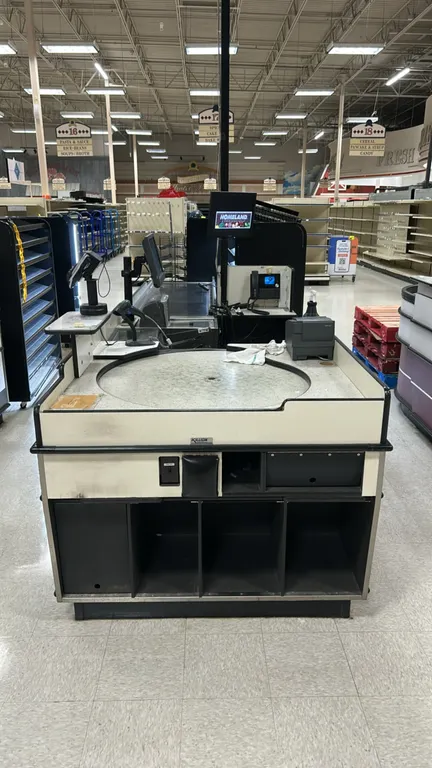 Killion checkout lane. Features laminate construction, single motorized conveyor belt, rotating turntable bagging station, cashier workstation, and lo