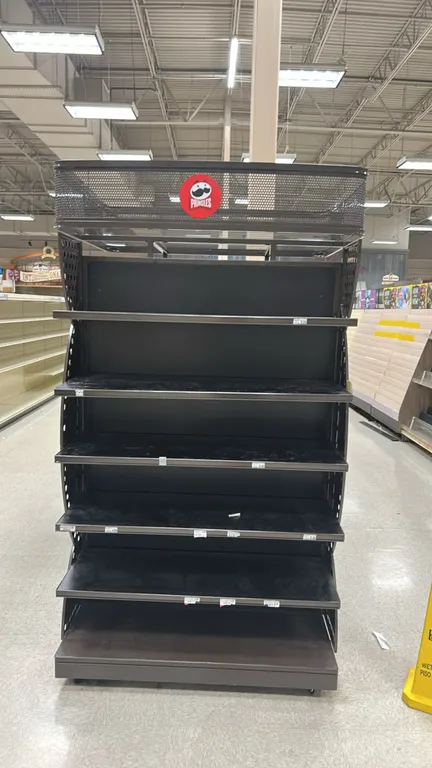 3-sided metal multi-tier display merchandiser. Features multi-tier adjustable metal shelving, top wire mesh header with branding graphics, and decorat