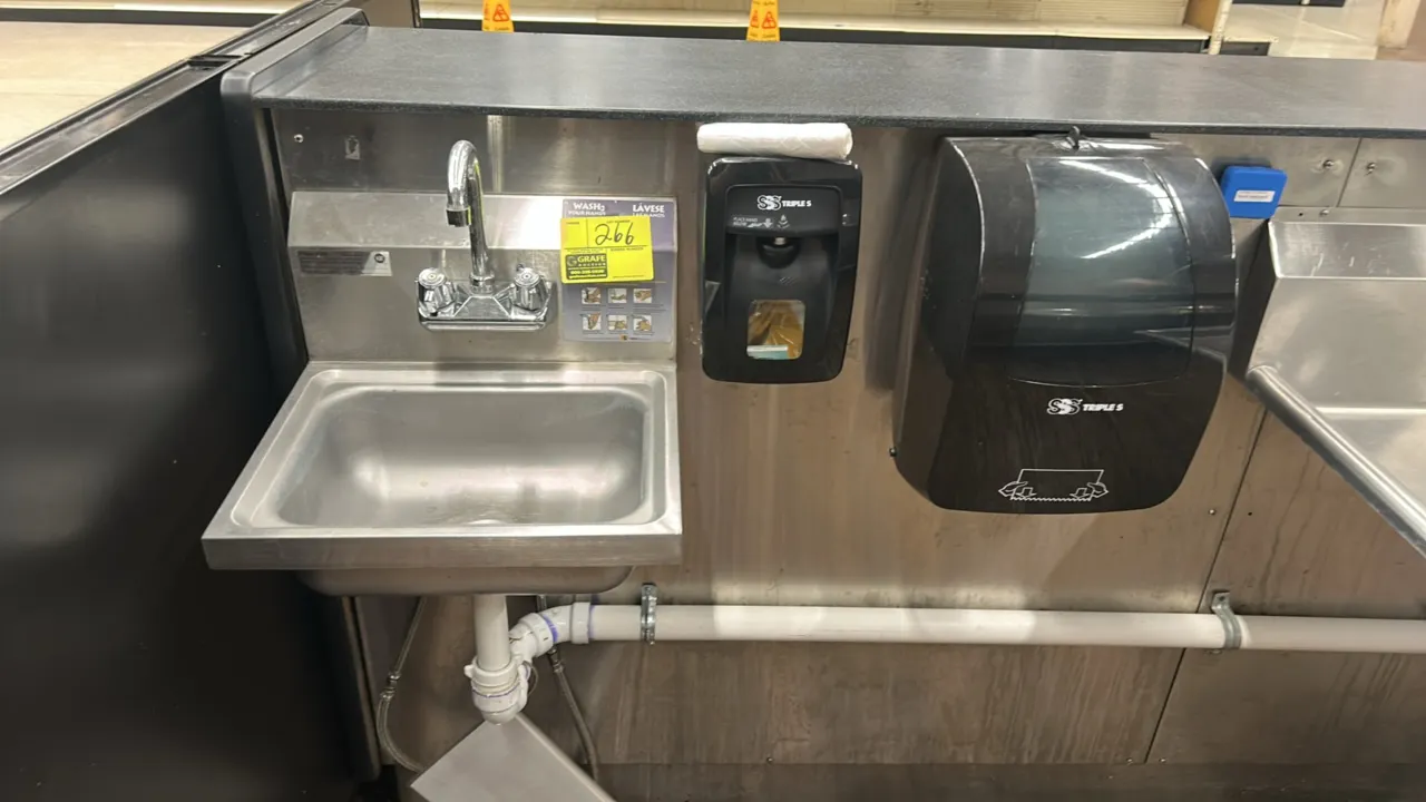 Stainless steel handwashing sink. Features a gooseneck faucet with dual controls, integrated backsplash, Triple S soap dispenser, and Triple S paper t