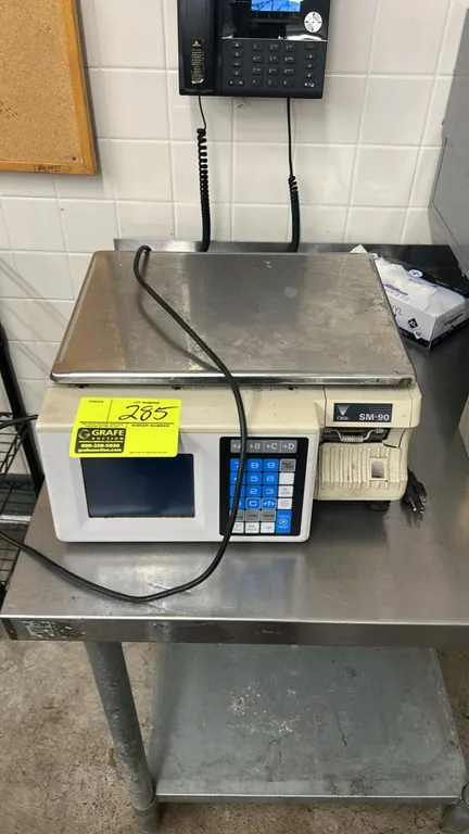 DIGI SM-90 commercial digital scale with label printer. Features stainless steel weighing platter, digital display, keypad interface, and integrated t