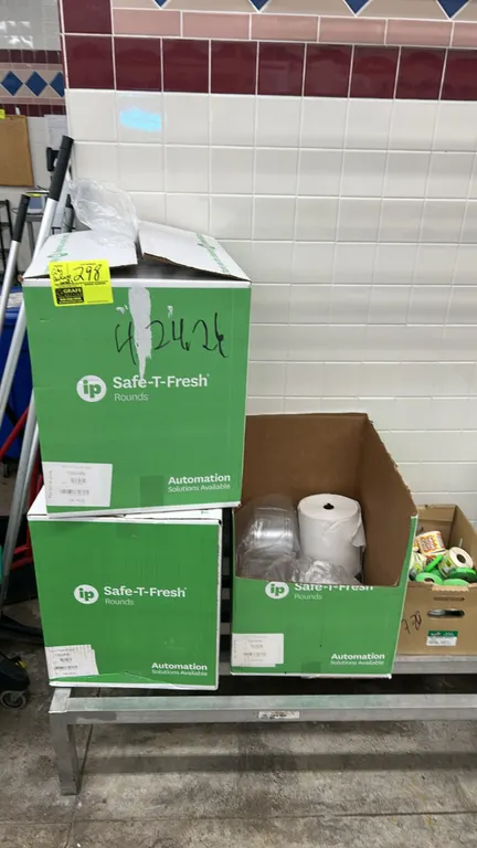 Assorted food packaging supplies. Includes Inline Plastics Safe-T-Fresh clear plastic hinged containers, round bowls, and paper roll in multiple cases