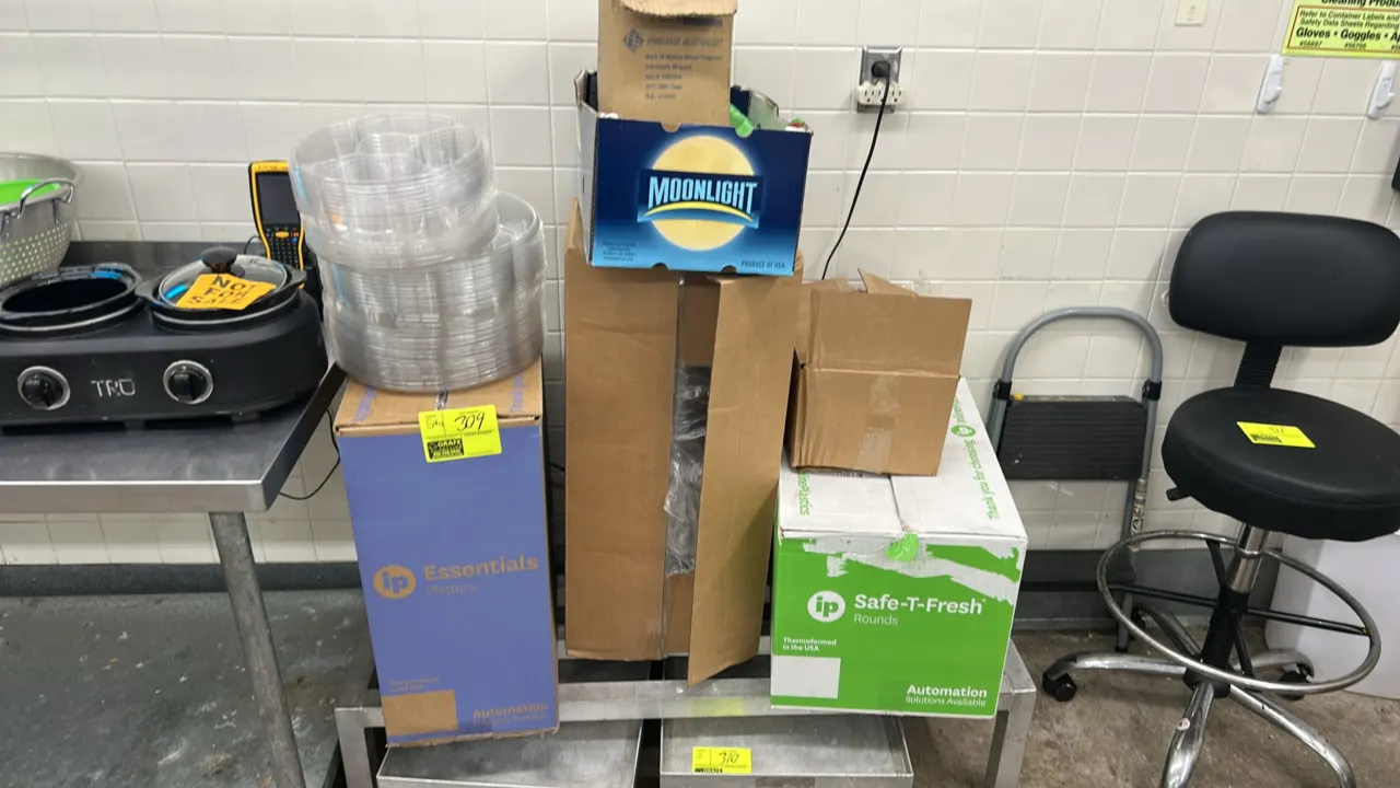 Assorted disposable food packaging supplies and containers. Includes Inline Plastics Safe-T-Fresh rounds, Essentials platters, clear plastic multi-com