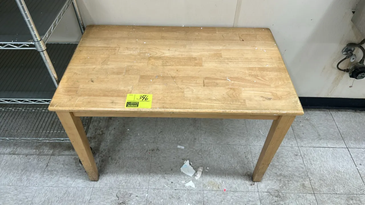 Wooden table. Features butcher-block style wood top and four wooden legs. 40"W x 24"D.