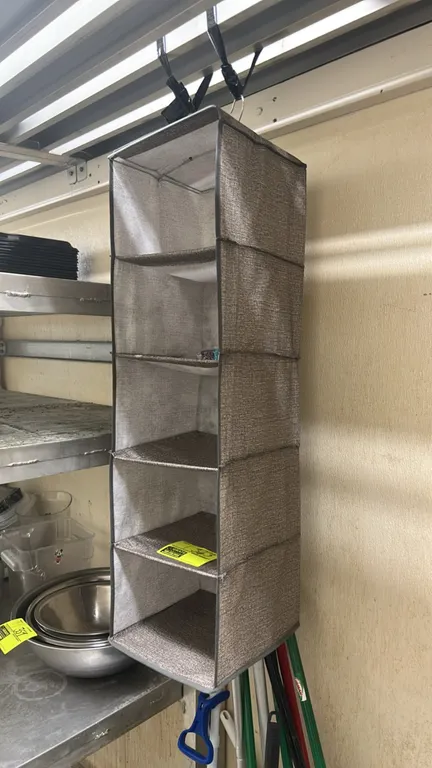 5-tier hanging fabric organizer. Features 5 open shelf compartments, durable fabric construction with a heathered gray-brown finish, and dual top hang