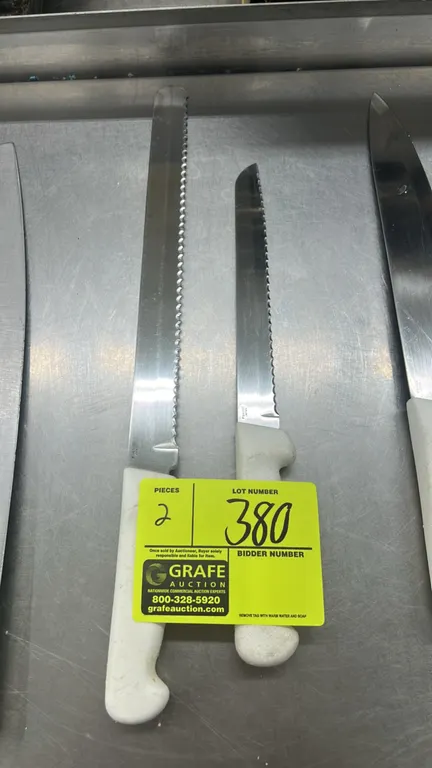 Dexter-Russell stainless steel serrated kitchen knives. Features serrated blades and white textured plastic handles.