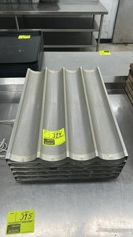 Perforated metal 5-channel baguette baking pans. Features 5-loaf curved channel design with perforated metal construction and reinforced outer framing